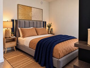 Ein modernes Schlafzimmer mit einem Bett, Nachttischen, einem Teppich und einem Wandbild.
