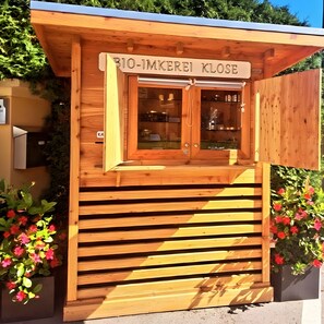Eine Holzhütte mit einem Schild, auf dem 'BIO-IMKEREI KLOSE' steht.