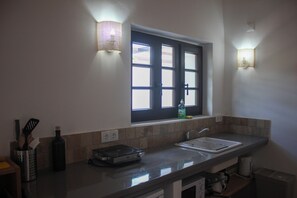 Una cocina con ventana, un lavamanos y una encimera.