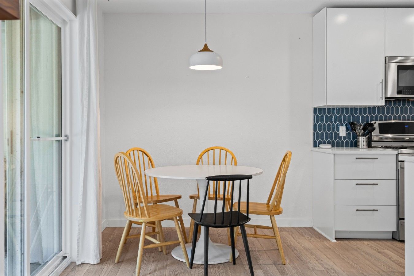 Enjoy meals together at the round dining table for four beside the sunny sliding patio door.