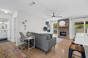 Ein modernes Wohnzimmer mit einem grauen Sofa, einem weißen Schreibtisch und einem Kamin.