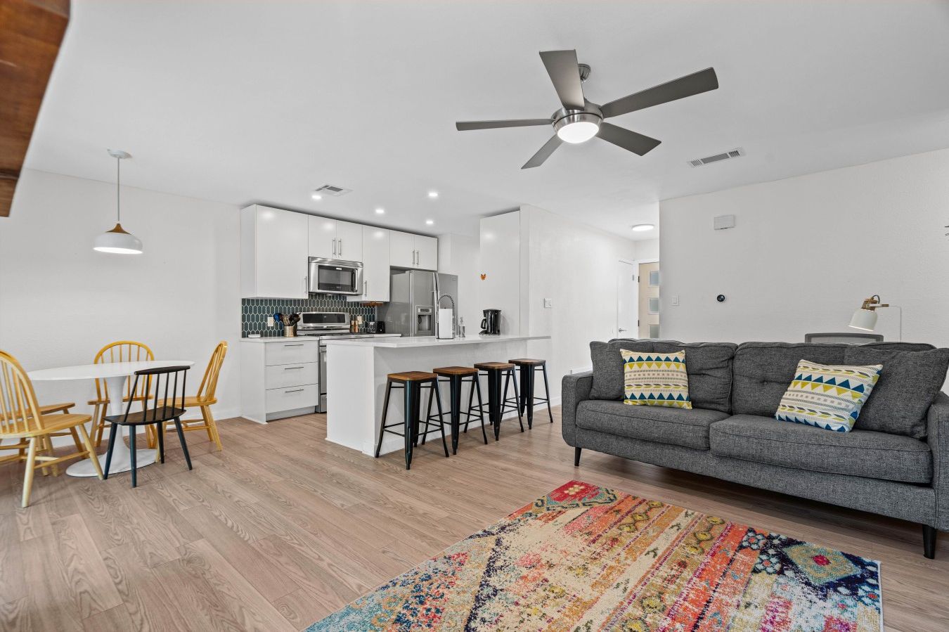 Open-concept living, dining, and kitchen keep the whole group connected under one breezy ceiling fan.