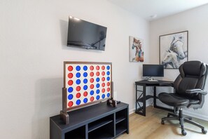 A room with a flat-screen TV, a desk with a computer, a gaming table, and a black office chair. - ★★ Springs & Saddles ★★ 
Dunnellon Getaway Near Ocala & Rainbow Springs (Dunnellon)