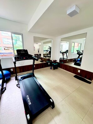 Ein Fitnessstudio mit Laufbändern, Gewichten und Trainingsgeräten.