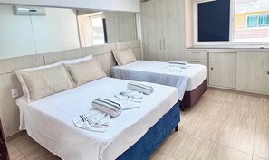 A hotel room with two beds, a large mirror, a window, and a wardrobe. - Cumbuco Beach Place 03 – Piscina + 100 metros Mar (Caucaia)