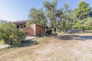 A house with a tiled roof, surrounded by dry grass and trees. - Zanteva-Psophis Cottage, Zanteva Cottages (Zakynthos)