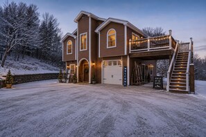 Une maison à deux étages avec un porche couvert, un escalier et une allée.