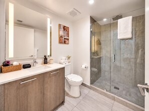A modern bathroom with a large mirror, a shower enclosure, and a toilet. - Modern Luxury Miami Apartment with Pool & Gym (Miami)