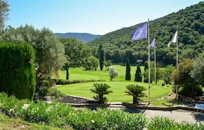 A well-maintained golf course with manicured lawns, a variety of trees, and a mountainous backdrop. - Awesome home in La londes les maures (La londes les maures)