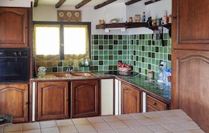 A kitchen with wooden cabinets, a green tiled backsplash, a sink, and a stove. - Awesome home in La londes les maures (La londes les maures)