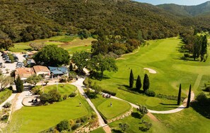 A golf course with a clubhouse, parking area, and surrounding greenery. - Awesome home in La londes les maures (La londes les maures)