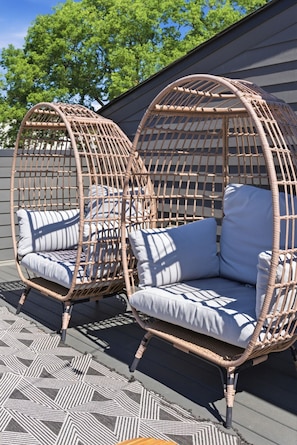 Two wicker outdoor sofas with cushions, placed on a patterned rug, against a building facade. - Downtown Rooftop Sleeps 10 Near Gulch and 12 South (Nashville)
