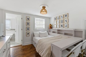 A bedroom with a bed, bedside tables, a desk, and a shelving unit. - Sleeps 12 - Dog-Friendly Nashville Cottage (Nashville)