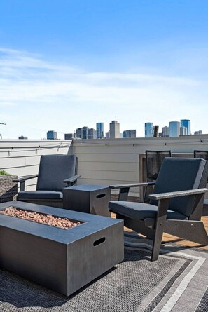 Une terrasse sur le toit avec des sièges extérieurs et un foyer.