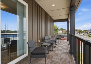 A balcony with outdoor seating, a view of the water, and a clear sky. - Modern Nashville Retreat Near Downtown & Music Row (Nashville)