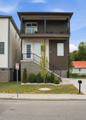 A two-story residential building with a front entrance, a small front yard, and a visible mailbox. - WeHo 8BR Retreat | Two Homes, Room for 24 (Nashville)