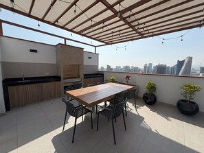 An outdoor patio with a table and chairs, a grill, and potted plants. - Dept. Brand-New, Central, and Modern Family Home (Pet-Friendly and Free Parking) (Lima)