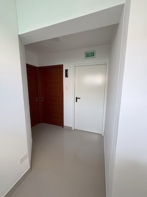 A corridor with a white door marked 'SALIDA' and a wooden door. - Dept. Brand-New, Central, and Modern Family Home (Pet-Friendly and Free Parking) (Lima)