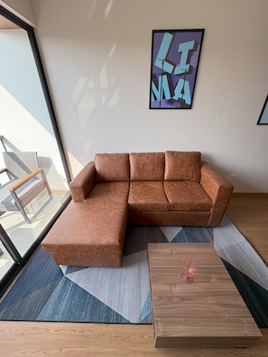 A modern living room with a brown sectional sofa, a wooden coffee table, and a geometric-patterned rug. - Dept. Brand-New, Central, and Modern Family Home (Pet-Friendly and Free Parking) (Lima)