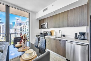 A modern kitchen with a large window, stainless steel appliances, and a city view. - High Rise Ocean View Downtown Miami (Miami)