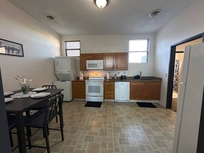 A compact kitchen with a stove, microwave, and dishwasher. - The Downtown Hideaway – Stylish 1BR Comfort (Greensboro)