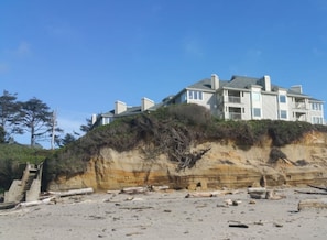 Une vaste propriété en bord de mer, composée de plusieurs étages, avec un escalier menant à l’entrée.
