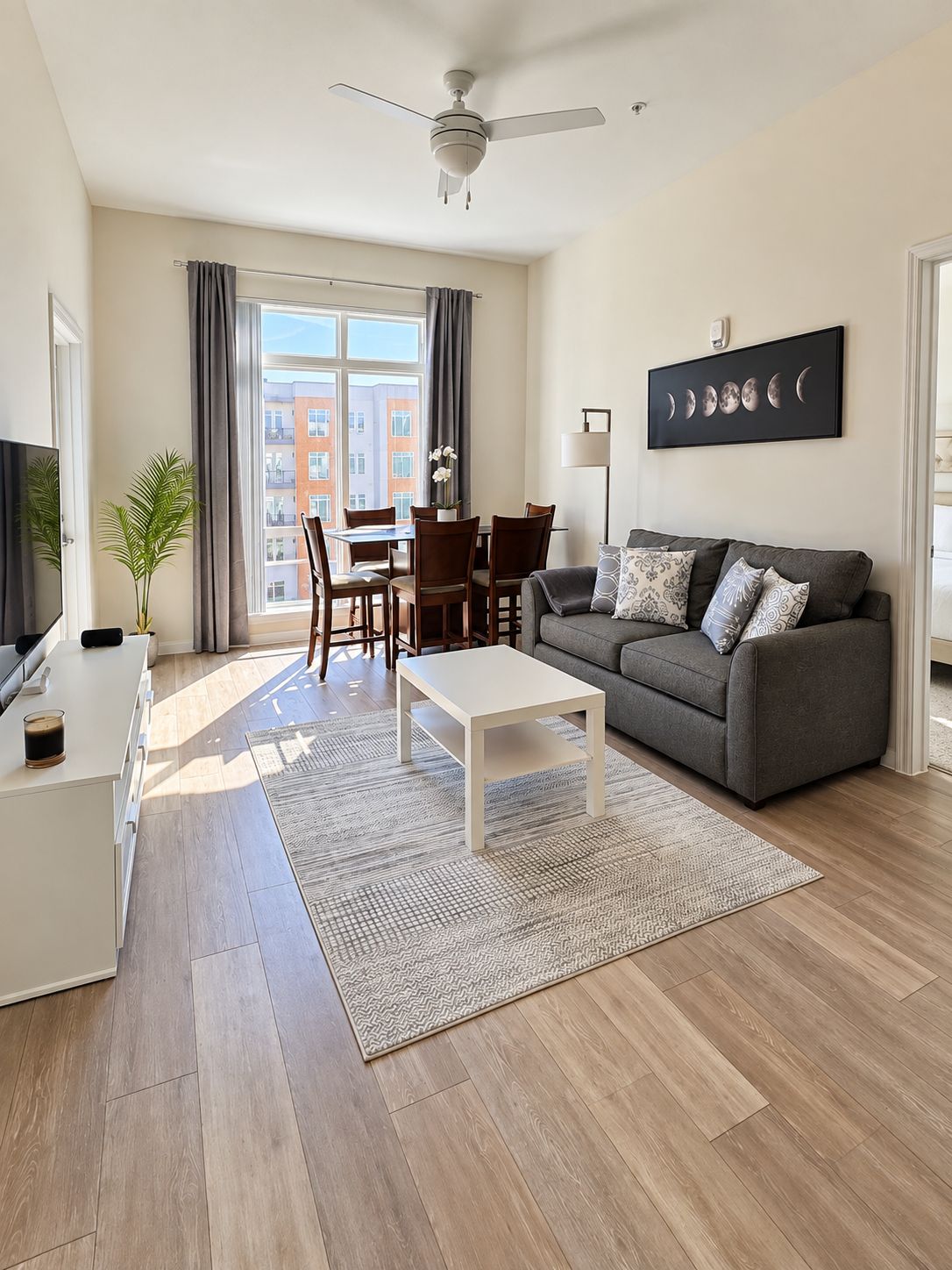 Ein modernes Wohnzimmer mit Sofa, Couchtisch und einem Essbereich mit Stühlen und Tisch.