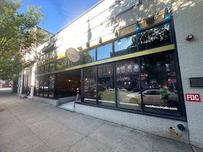 A storefront with large windows displaying hand-crafted cocktails and wine & charcuterie. - Walkable Downtown King Bed Near Food and Nightlife (Greensboro)