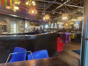 A bar area with a counter, seating, and decorative lighting. - Walkable Downtown King Bed Near Food and Nightlife (Greensboro)