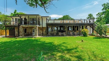 A two-story house with a patio area and a stone facade.