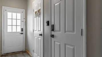 A hallway with two white doors, one labeled '11' and another with a decorative sign.