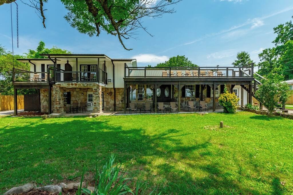 A two-story building with a stone facade, a balcony, and outdoor seating area.