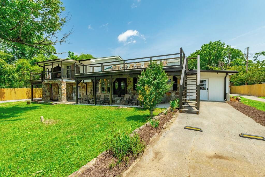 A two-story house with a covered patio, a small garden, and a garage.