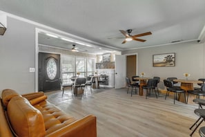 Ein großzügiger Wohnbereich mit Ledersofa, Esstischen und Deckenventilatoren.