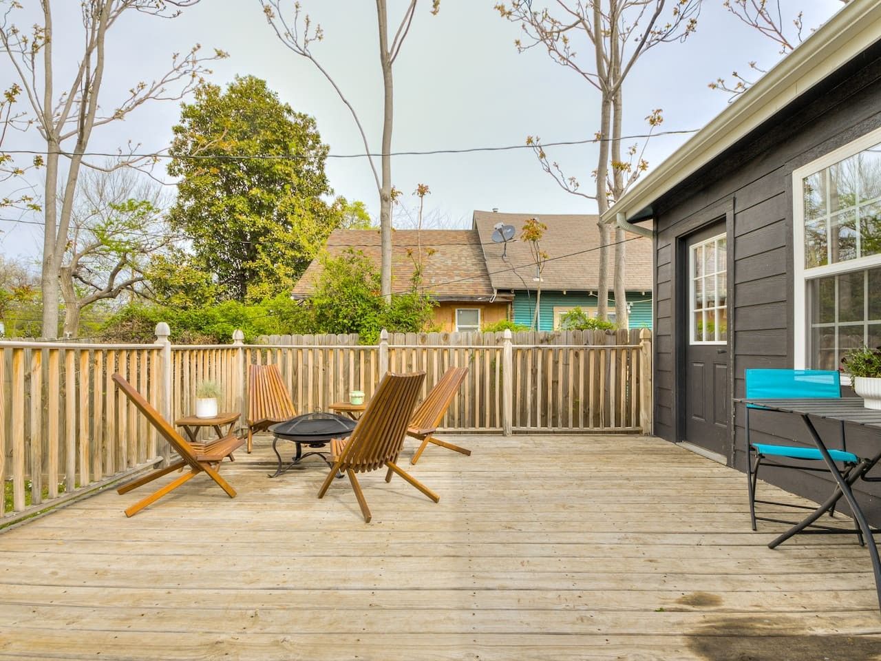 A wooden deck with outdoor furniture, including chairs and a table.
