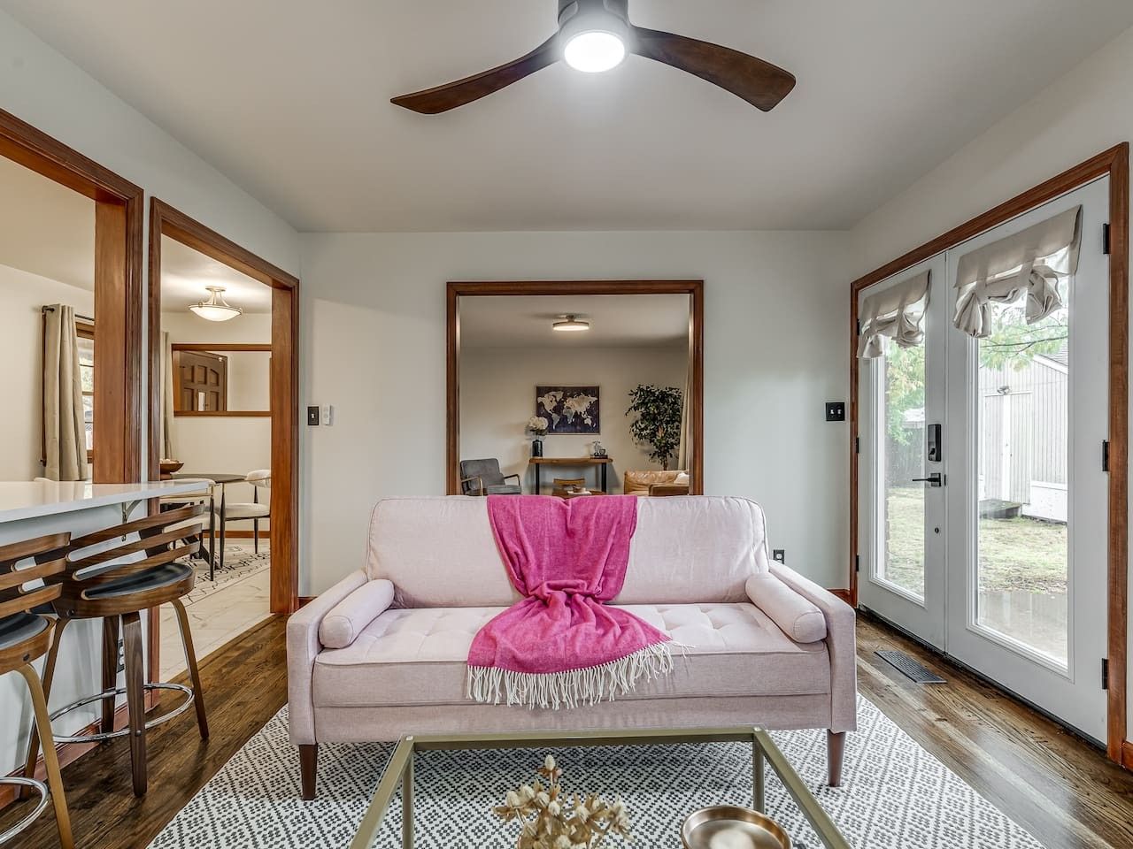 A living room with a sofa, coffee table, and a ceiling fan.