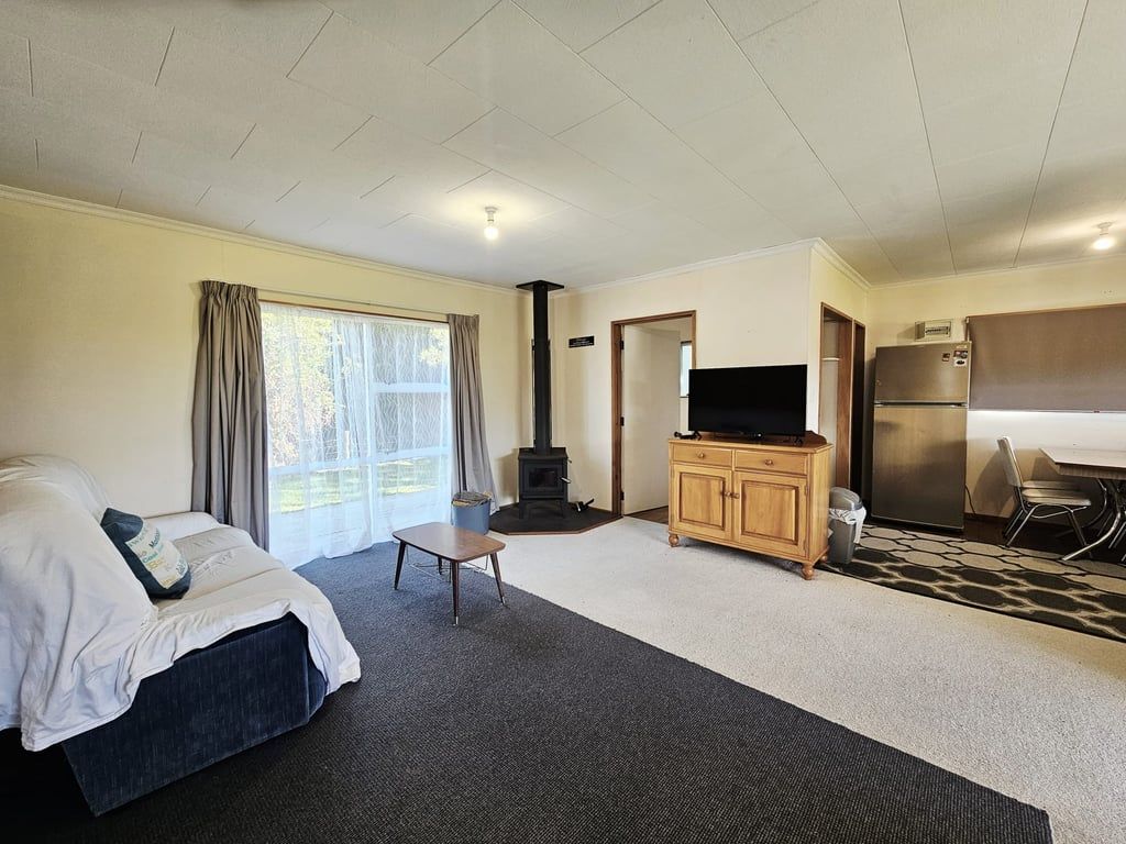 Habitación de hotel con cama, televisión, chimenea, refrigerador y comedor.