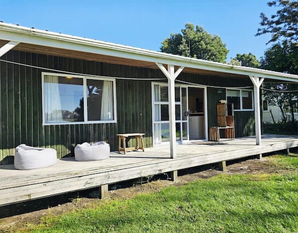 A single-story building with a covered porch, large windows, and a visible door.
