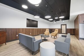 A modern lounge area with sofas, tables, and a flat-screen TV. - Downtown 1BR | Gym + Coworking Area + Balcony (Kitchener)