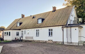 A white building with a sloped roof, multiple windows, and a ladder on the side. - 7 bedroom stunning home in östra ljungby (Östra Ljungby)