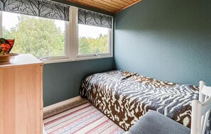 A bedroom with a bed, a desk, a window, and a view of trees. - 4 bedroom gorgeous home in örkelljunga (Örkelljunga)