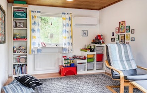 A child's playroom with a window, shelves with toys, a red stool, and a chair. - 4 bedroom gorgeous home in örkelljunga (Örkelljunga)