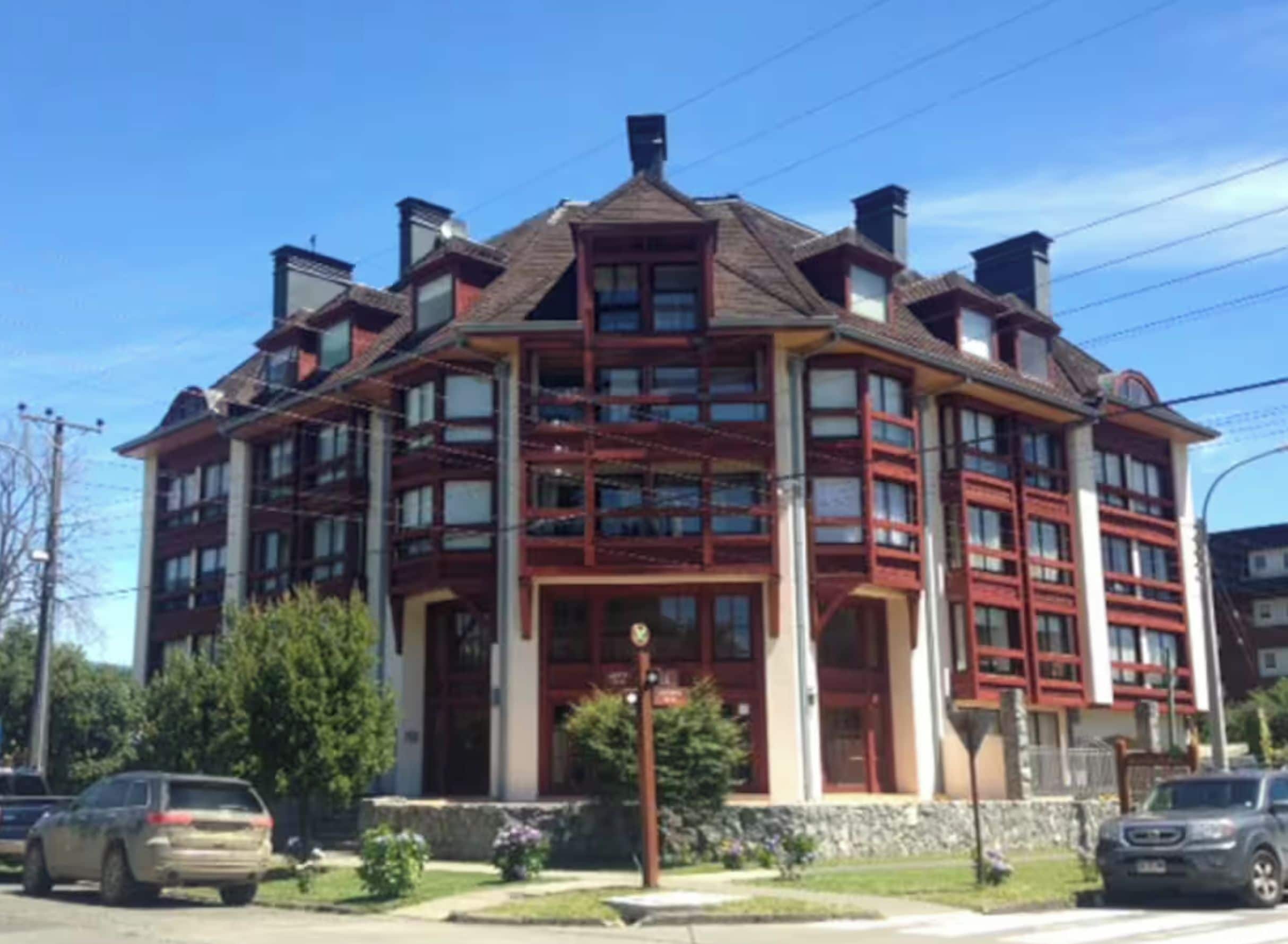 A multi-story building with a central entrance, large windows, and a symmetrical facade.