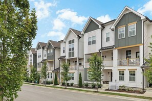 A row of townhouses with multiple stories, balconies, and a clear sky. - Music City Home Base | Office + 98" TV | 30+ Days (Nashville)