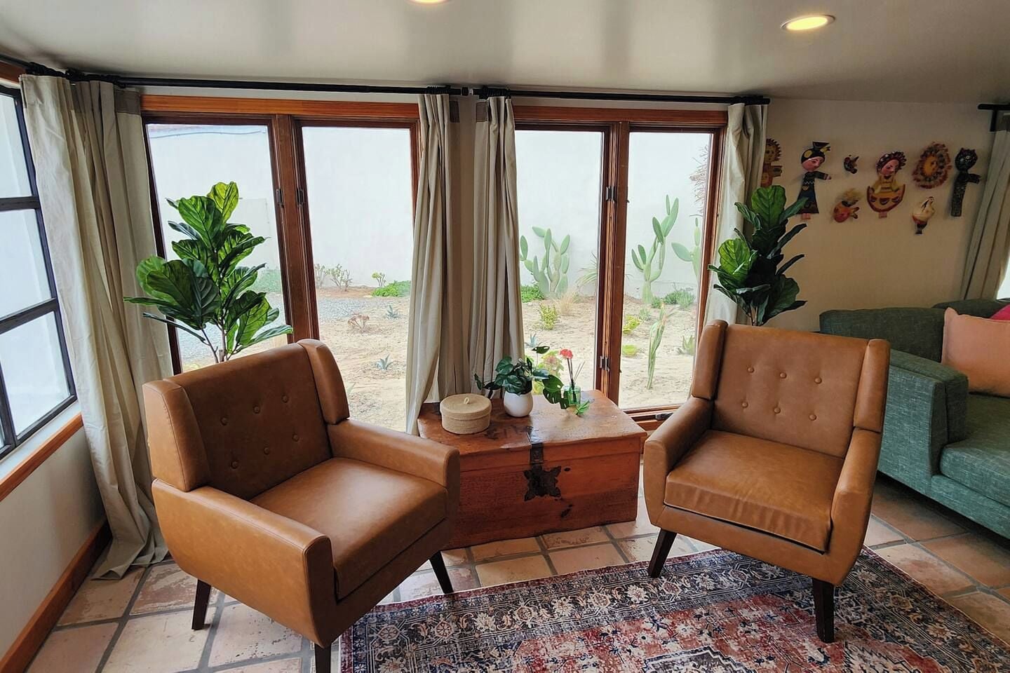 A room with two leather armchairs, a wooden coffee table, and a patterned rug.