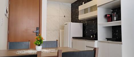 A modern kitchen with a marble backsplash, white cabinetry, and a built-in oven.