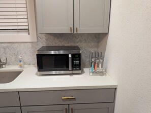A kitchen with a microwave, a sink, and a utensil holder. - Cozy Southtown nearby King Williams home. Nearby Alamodome and Frost Bank Center (San Antonio)