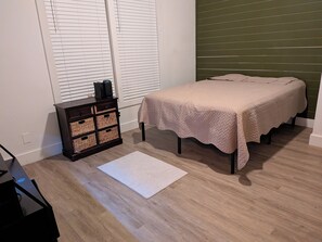 A bedroom with a bed, a nightstand, a storage unit, and a window with blinds. - Cozy Southtown nearby King Williams home. Nearby Alamodome and Frost Bank Center (San Antonio)