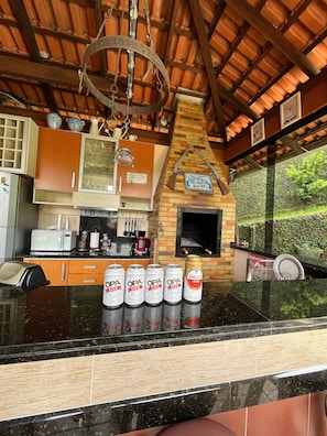 A kitchen with a brick oven, wooden cabinets, and a countertop with beer cans. - House of the Master Brewer (Blumenau)