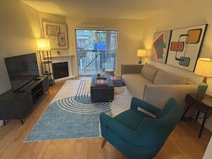 A living room with a television, sofa, coffee table, and a fireplace. -     Cozy 1BR Near Dallas Medical District  - Furnished + Utilities (Dallas)